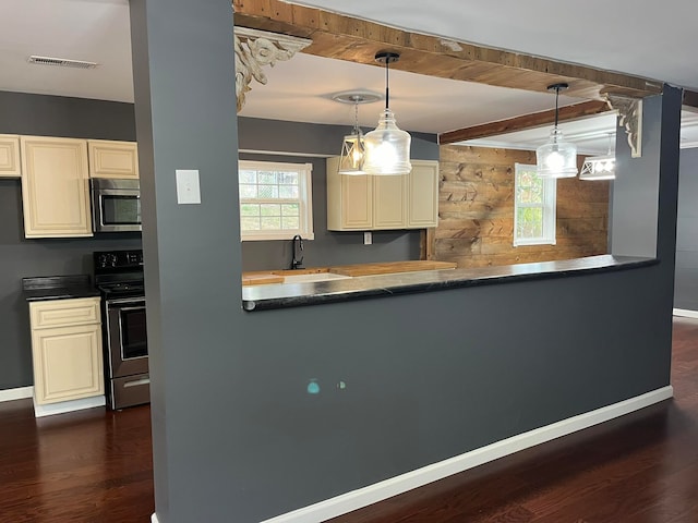 kitchen with beam ceiling, dark wood-type flooring, sink, pendant lighting, and appliances with stainless steel finishes