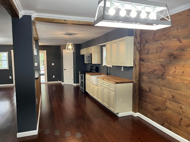 kitchen featuring dark wood-style floors, wooden walls, butcher block counters, and stainless steel appliances