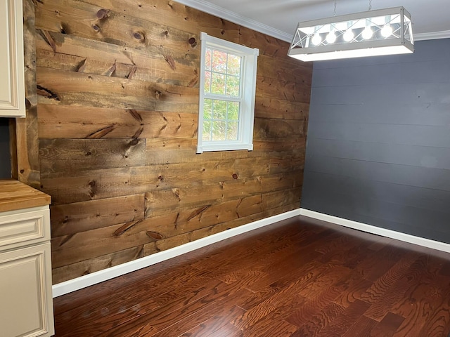 interior space with crown molding, hardwood / wood-style floors, and wooden walls