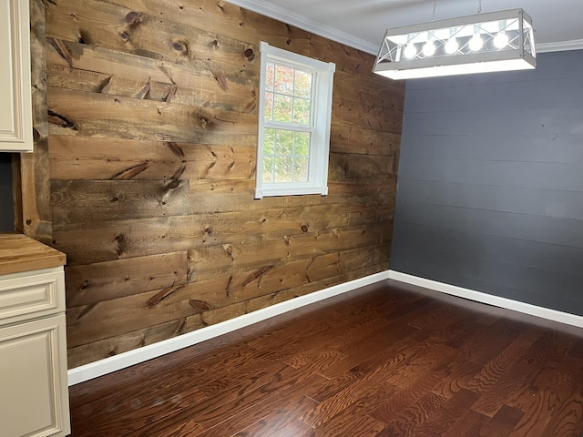 unfurnished room with ornamental molding, baseboards, dark wood-style floors, and wood walls