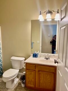 bathroom with a notable chandelier, vanity, tile patterned flooring, and toilet