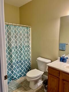 bathroom featuring vanity, tile patterned flooring, toilet, and curtained shower