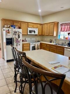 kitchen with light tile patterned floors, sink, and white appliances