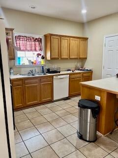 kitchen featuring sink, light tile patterned floors, and white dishwasher