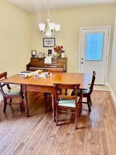 dining space with light hardwood / wood-style floors and a chandelier