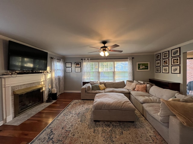 living room with a ceiling fan, a tile fireplace, and crown molding