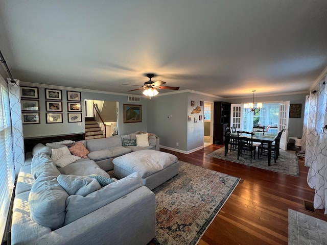 living room featuring ceiling fan with notable chandelier, ornamental molding, and dark wood-type flooring