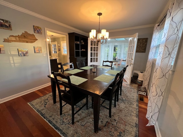 dining space with ornamental molding, french doors, dark wood-type flooring, and a notable chandelier