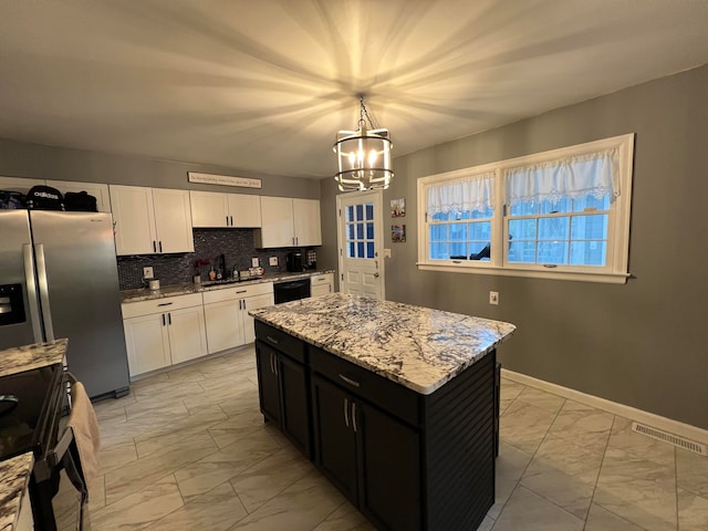 kitchen featuring white cabinetry, hanging light fixtures, backsplash, a kitchen island, and black appliances