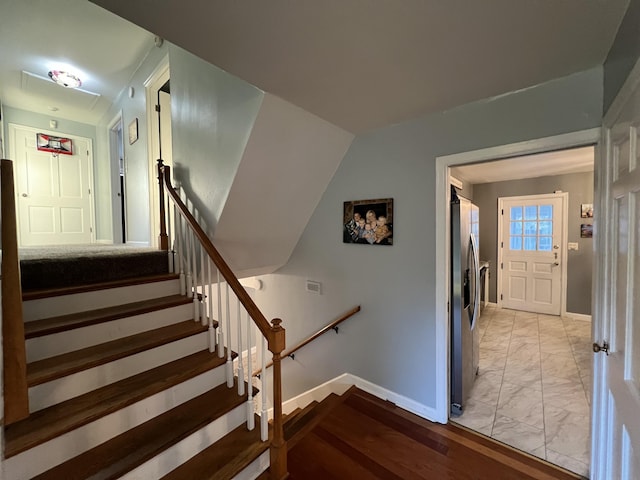 stairway with marble finish floor and baseboards