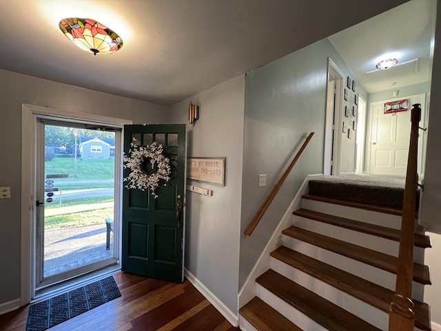 entrance foyer featuring baseboards, dark wood-style floors, and stairway