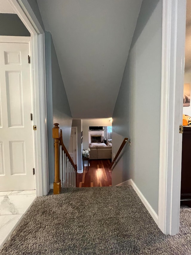 staircase featuring wood-type flooring and vaulted ceiling