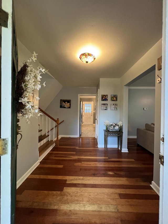 foyer with baseboards, stairway, and wood-type flooring