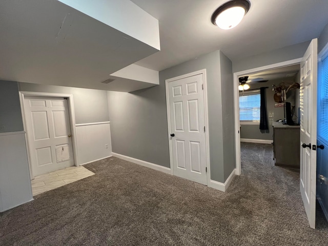 bonus room featuring ceiling fan and dark carpet