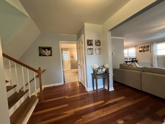 corridor featuring wood-type flooring, baseboards, and stairs