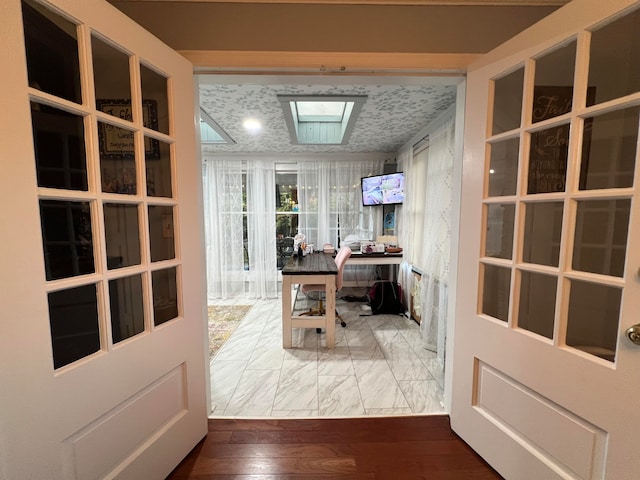 office with hardwood / wood-style flooring and a skylight