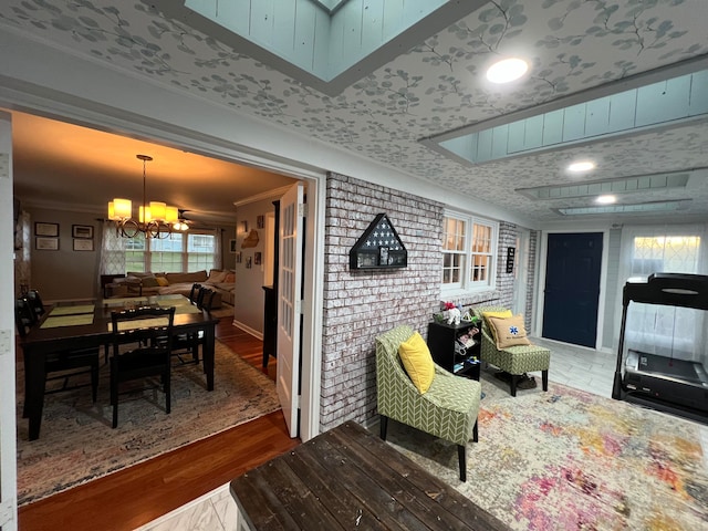 living room featuring hardwood / wood-style floors, crown molding, and a notable chandelier