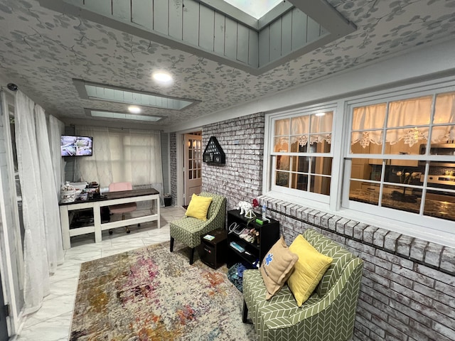 interior space featuring a skylight and brick wall