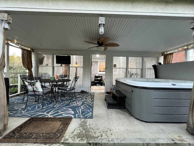 view of patio featuring fence, ceiling fan, outdoor dining area, and a hot tub