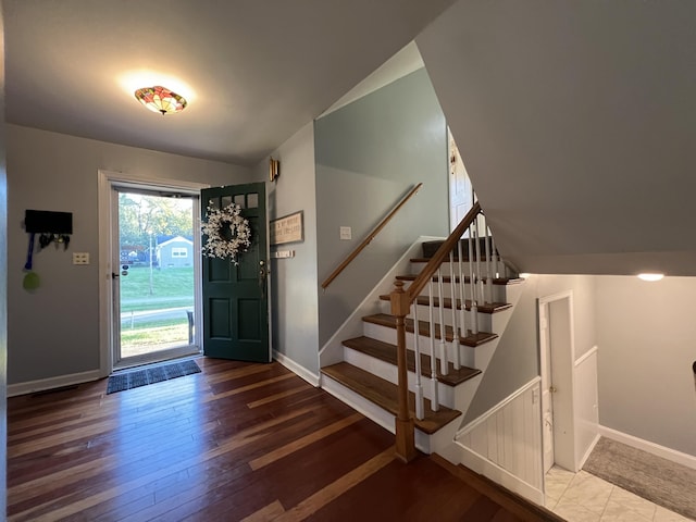entryway featuring hardwood / wood-style flooring, baseboards, and stairs