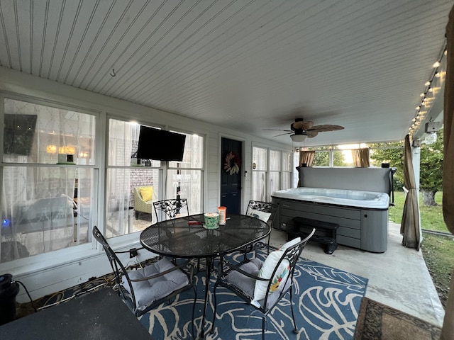 view of patio with a ceiling fan, a hot tub, and outdoor dining space