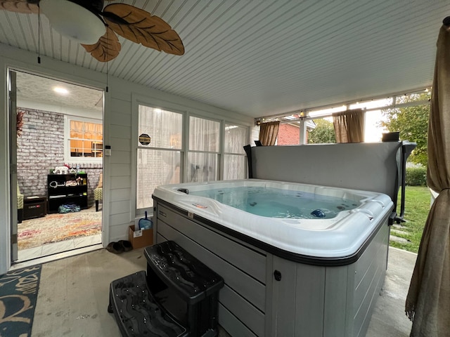 view of patio with ceiling fan and a hot tub