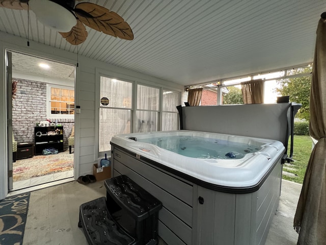 sunroom with a ceiling fan and a hot tub