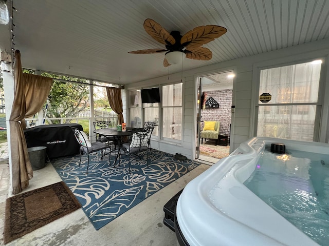 sunroom / solarium featuring a jacuzzi and ceiling fan