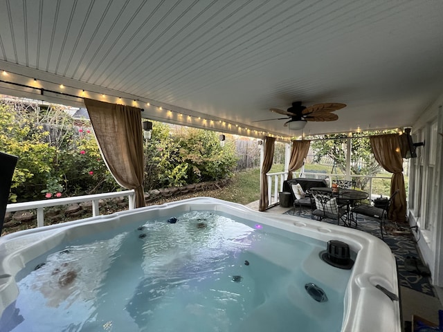 exterior space with outdoor dining area, fence, a hot tub, and a ceiling fan