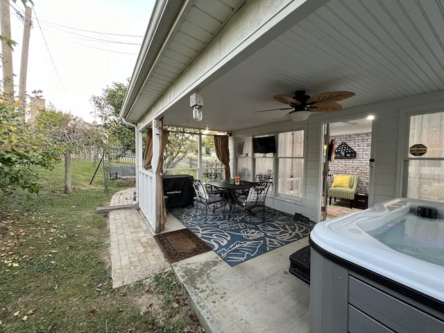 view of patio / terrace featuring a hot tub, outdoor dining area, ceiling fan, and fence