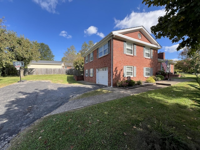 view of side of home featuring fence, a garage, brick siding, a lawn, and aphalt driveway