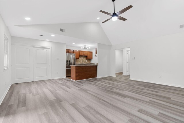 unfurnished living room with light hardwood / wood-style flooring, high vaulted ceiling, and ceiling fan