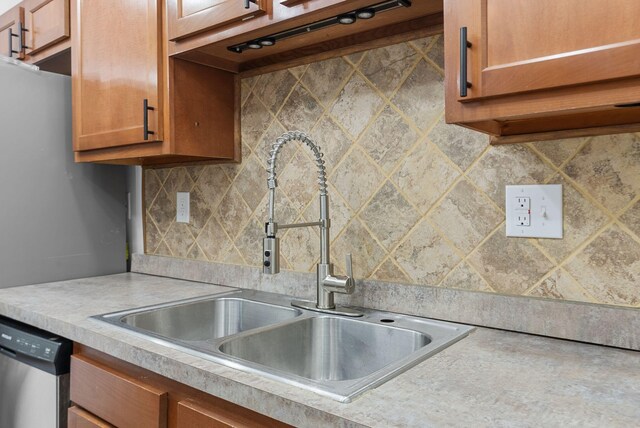 kitchen with decorative backsplash, stainless steel dishwasher, and sink