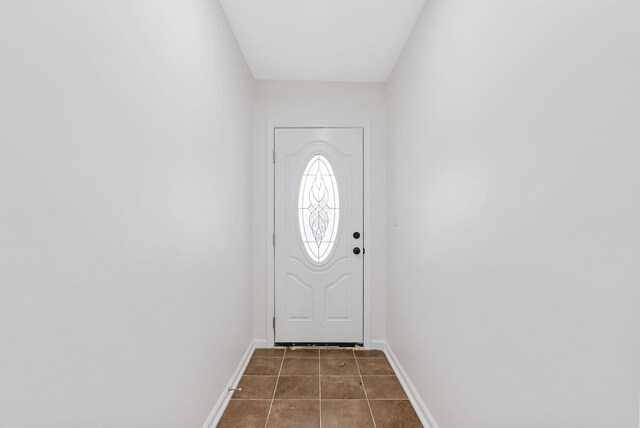 doorway to outside featuring dark tile patterned floors