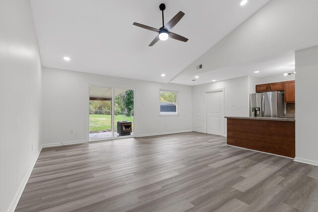 unfurnished living room featuring high vaulted ceiling, light wood-type flooring, and ceiling fan