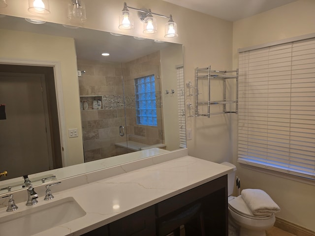 bathroom featuring toilet, an enclosed shower, and vanity