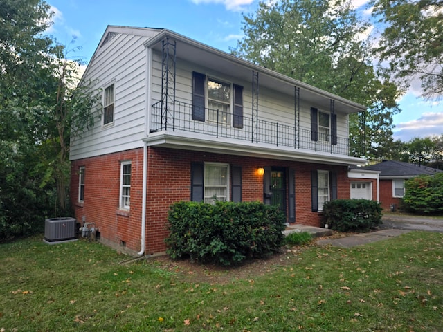 view of property with central air condition unit, a balcony, and a front lawn