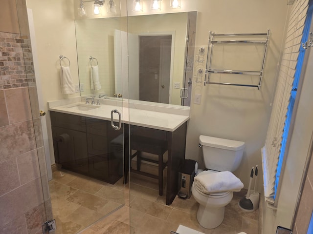 bathroom with a shower with door, vanity, and toilet