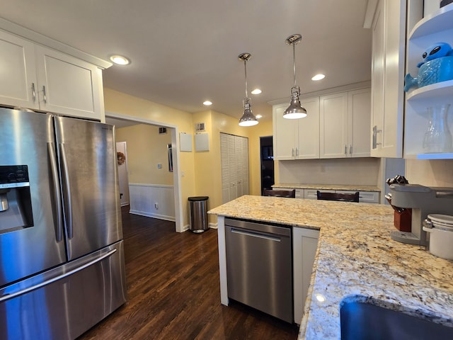 kitchen with dark wood-type flooring, stainless steel appliances, pendant lighting, and white cabinets