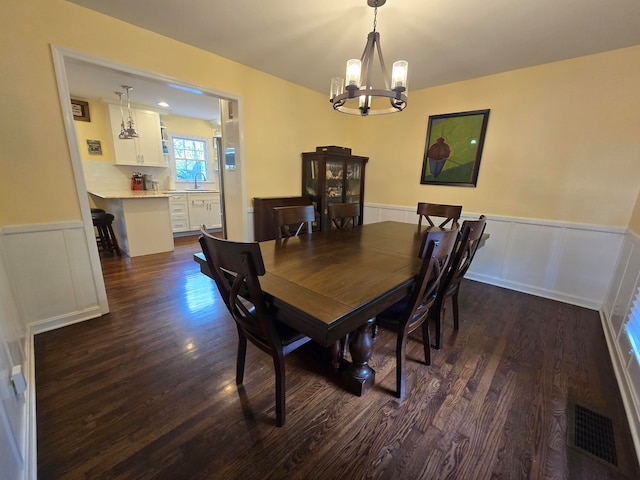 dining space with sink, a chandelier, and dark hardwood / wood-style flooring