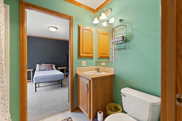 bathroom with vanity, toilet, and ornamental molding