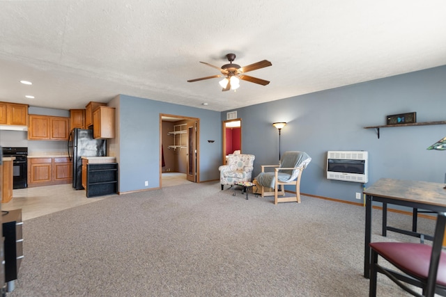 interior space with a textured ceiling, ceiling fan, heating unit, and light colored carpet