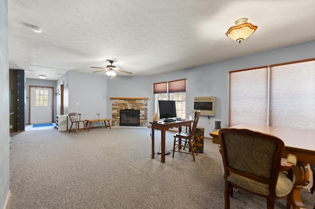 interior space with a textured ceiling, heating unit, a fireplace, and ceiling fan