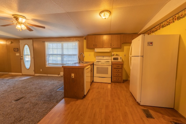 kitchen with ceiling fan, white appliances, sink, light hardwood / wood-style floors, and vaulted ceiling