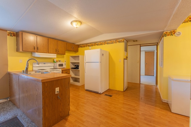 kitchen with lofted ceiling, sink, kitchen peninsula, white appliances, and light wood-type flooring