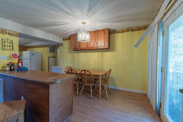 179 Bill Patrick Rd, Whitley City, KY 42653 - dining room with light wood-style flooring, a chandelier, baseboards, and a textured ceiling