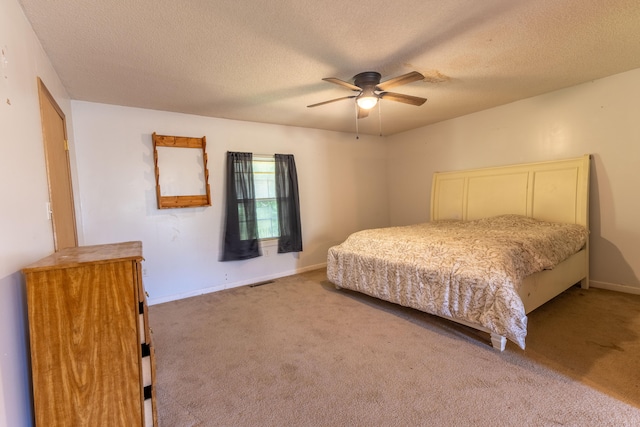 bedroom with ceiling fan, a textured ceiling, and carpet