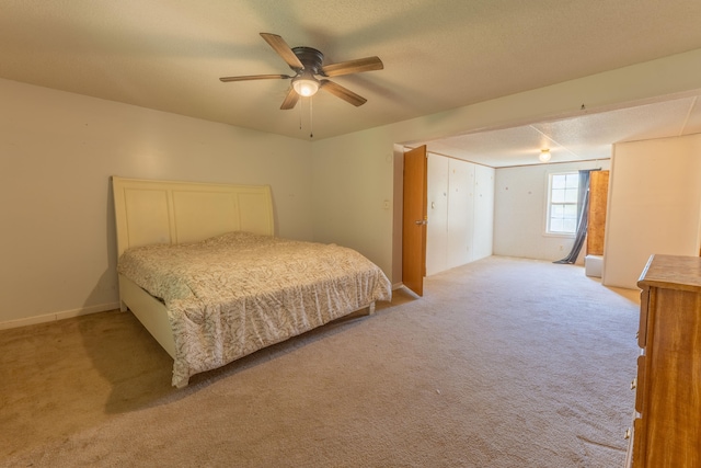 carpeted bedroom with ceiling fan and a textured ceiling