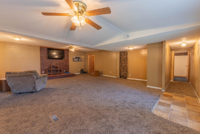 unfurnished living room with vaulted ceiling, a brick fireplace, carpet flooring, and ceiling fan