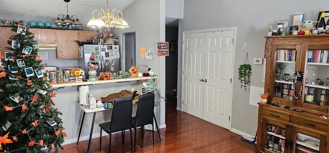 kitchen featuring hanging light fixtures, dark hardwood / wood-style flooring, a chandelier, and stainless steel fridge